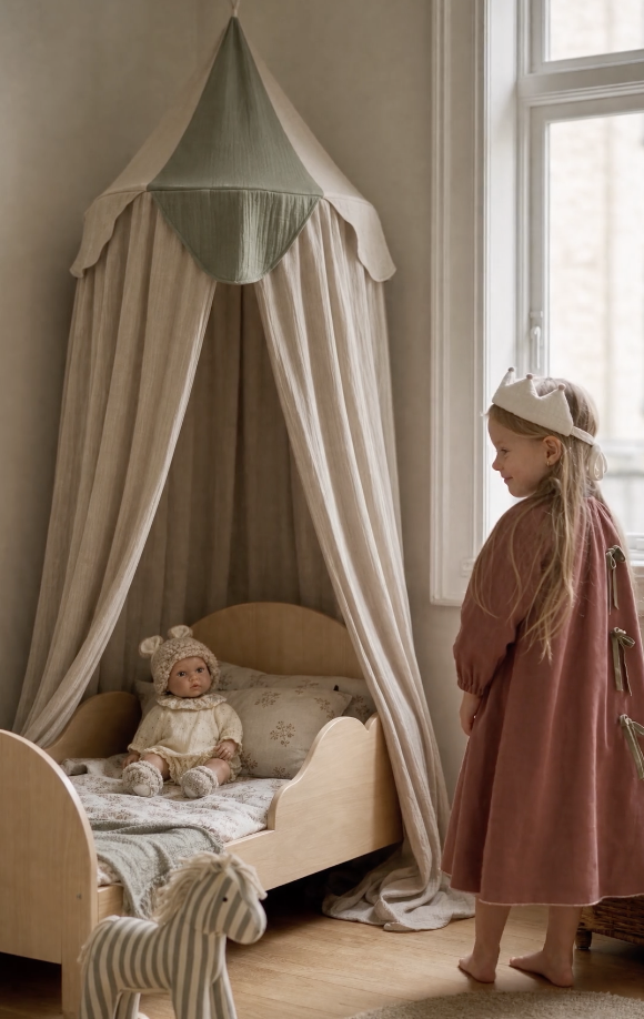Barababy beige and green bed canopy in a lifestyle scene with a girl beside the bed