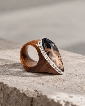 W.Ritzdorf sculptural statement ring with a teardrop-shaped centre in a product photograph on pale stone